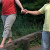 couple balancing on fence
