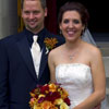 bride and groom pose in front of church